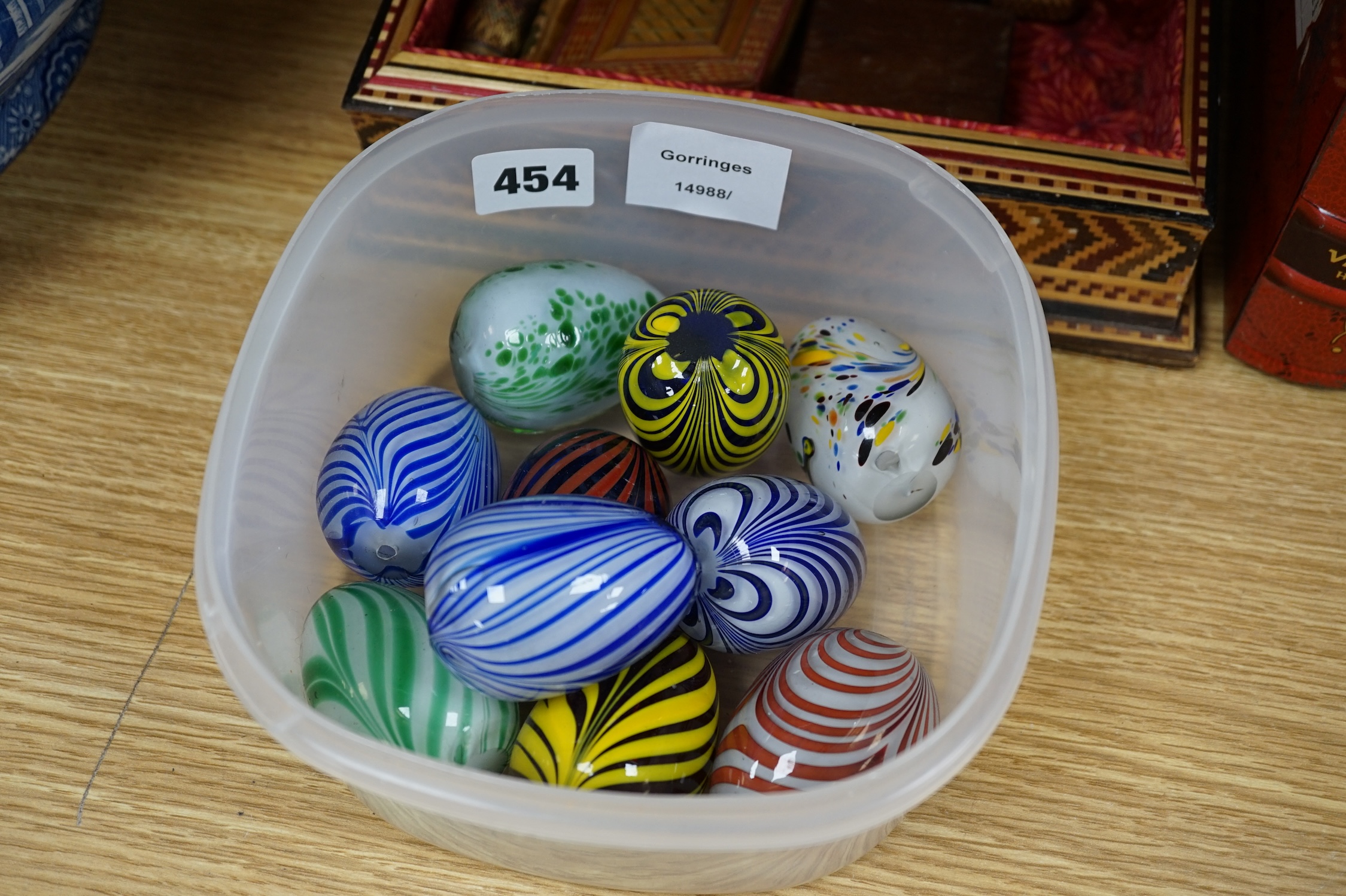 Sundry items to include glass eggs, marbles, a set of three tins in the form of books and a straw work box, etc. Condition - mostly fair